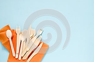 Wooden forks, spoons and knives on a blue background