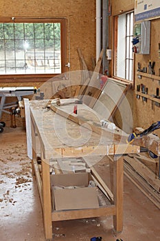 A wooden frame is bent on a workbench in a shipbuilding workshop