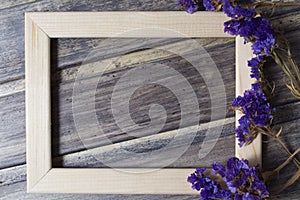 Wooden frame with dried blue flower decoration on the wooden table