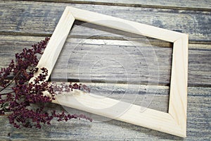 Wooden frame with dried flower decoration on the wooden table