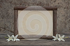 Wooden frame with flowers on the wooden table