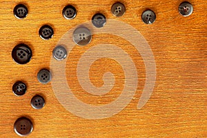 Wooden frame with a group of dark sewing buttons