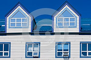 Wooden frame house blue metal roof dormer windows