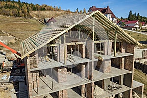 Wooden frame of new roof on a brick big house under construction