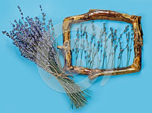 Wooden frames with bouquet of fragrant lavender in rustic style on blue wall. Holiday party decoration