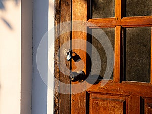 Wooden front door in a rustic wooden cottage. Rustic wooden cottage with locking door
