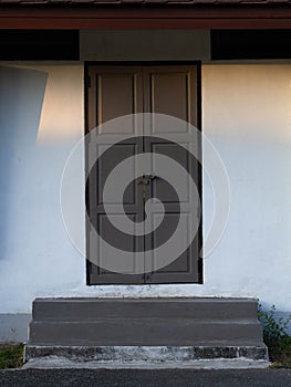 Wooden front door in a rustic wooden cottage. Rustic wooden cottage with locking door.