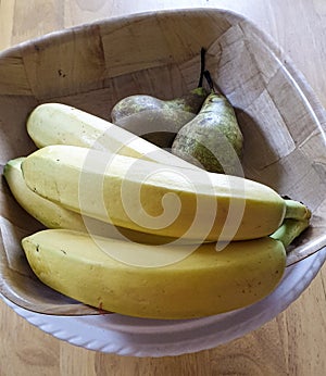 Wooden fruit bowl with bananas and pears