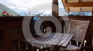 Wooden furniture on the balcony of a hotel room overlooking the mountains