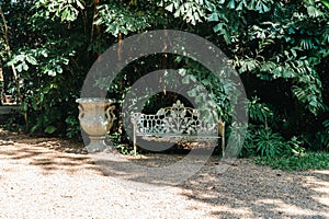 Wooden furniture in the garden against the backdrop of a fire on the patio. Among the branches of the bush stands a wooden table