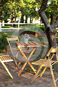 Wooden furniture set for Picnic in garden. Empty Wooden chairs and table on veranda of house.