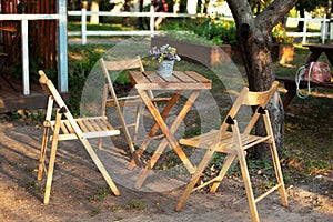 Wooden furniture set for Picnic in garden. Empty Wooden chairs and table on veranda of house. Ðžutdoor furniture for leisure time
