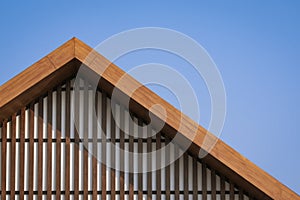 Wooden gable roof with battens decoration of vintage house against blue clear sky background