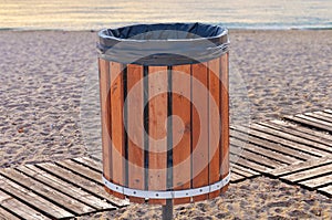 Wooden garbage can for rubbish on a sandy beach on a summer day