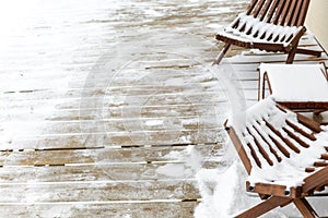 wooden garden furniture abandoned on a patio covered with snow