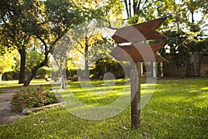 Wooden garden sign pointing down the path