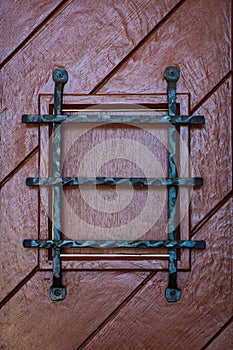Wooden gate with barred window