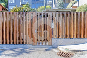 Wooden gate and fence of a residential building with doorbell camera intercom in San Francisco, CA