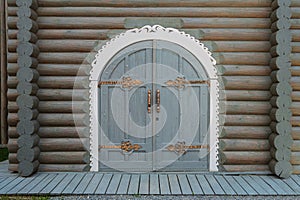 Wooden gate with forged overhead hinges in medieval style of wooden blockhouse