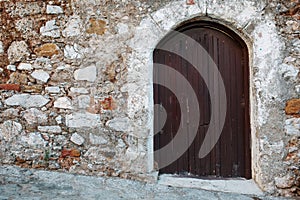 Wooden gate of an old castle made of stone with free space on the wall