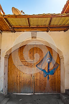 Wooden gate with a ribbon ornament and the inscription of the former owner of the house