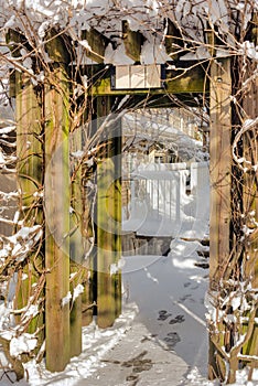 Wooden gate in snow. Winter in residential area on sunny day