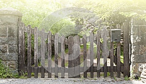 Wooden gate in a stone wall on a farm on sunlight