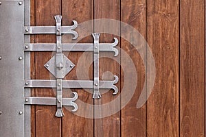 Wooden gate with wrought iron elements close up