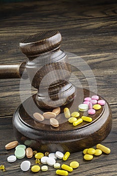 Wooden gavel with drugs on table