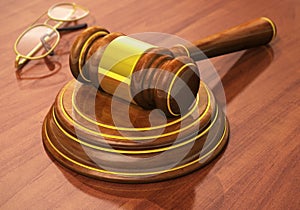 Wooden gavel and eyeglasses on table