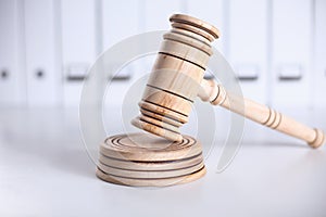 Wooden gavel and folders on wooden table, close up