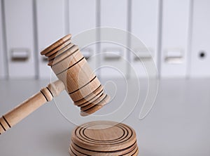 Wooden gavel and folders on wooden table, close up
