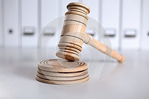 Wooden gavel and folders on wooden table, close up