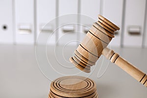 Wooden gavel and folders on wooden table, close up