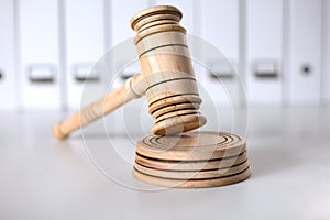 Wooden gavel and folders on wooden table, close up