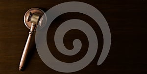 Wooden gavel, judges hammer or mallet on dark wood table background, law, legal or court symbol or concept, flat lay top view from