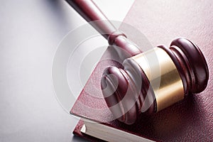 Wooden Gavel Resting on Red Leather Book