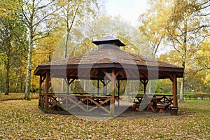 Wooden gazebo in autumn parks - relax and unwind