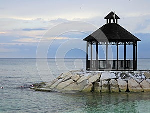 Wooden gazebo on sea rocks