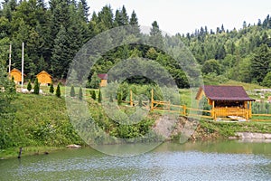 Wooden gazebos on shore of lake in Carpathians