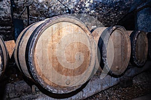 Wooden giant wine oak barrels stacked in rows. Aging, fermentation, store in old wine cellar. Concept sommelier trip