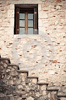 Wooden and glass window in a stone wall with stairs