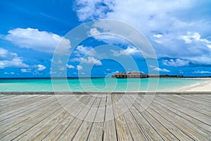 Wooden gray pier on perfect beach in sunny day with blue sky