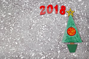 Wooden Green Christmas tree and sign 2018 from wooden redletters, gray concrete background. Happy new year 2018 backdrop.