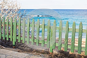 Wooden green fence on the beach