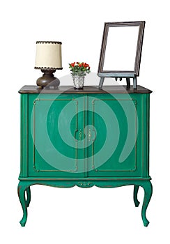 Wooden green vintage sideboard with empty desktop photo frame, flower planter, and table lamp isolated on white with clipping path