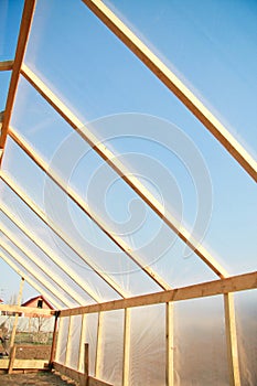 Wooden greenhouse covered with polyethylene photo