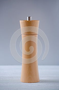 Wooden grinder for salt or pepper on gray background