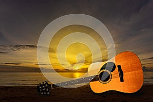 Wooden guitar on the sandy sea, sunrise, musical instruments with nature, the background music on the sea on a beautiful day,