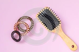 Wooden hair brushes, spirals for hair on pink background. beauty girl female concept